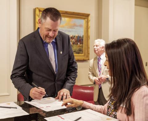 State Sen. Grant Green, R-Wellston, signs his oath of office on Statehood Day at the Capitol.