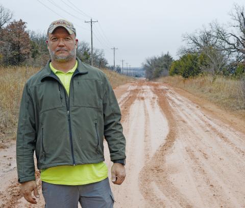 Lincoln County Commissioner Lee Doolen at one of the muddy roads in his district, north of Wellston. Photo/Brian Blansett