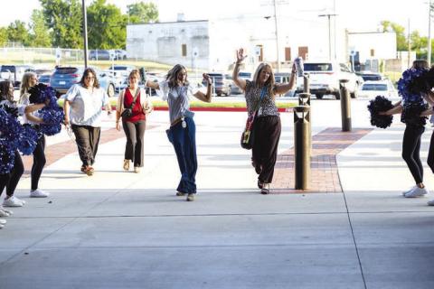 Lacey Echelle and Tonya Pennock, both first grade teachers at Stroud Public Schools, dance their way back to school, cheered on by the pom squad, cheerleaders and marching band on Aug. 3. Photo/Beth Young
