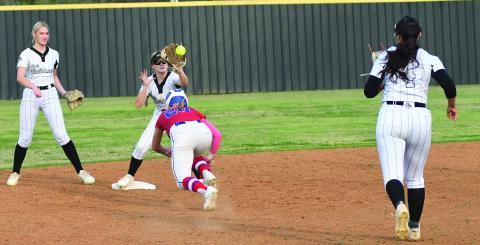 Chandler’s Ruthie Capps (20) dives back to second as Meeker’s Ryean Weaver takes the throw following a rundown in the Lady Lions’