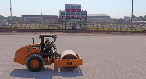 A roller levels and packs gravel where bermuda grass used to grow at the Prague football field. The Red devils are getting new turf on the football, softball and baseball fields. Photo/Stephanie Woolsey