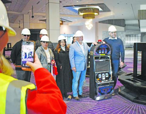 Iowa Tribe of Oklahoma Chairman Jacob Keyes (far right) stands with Harrahs Oklahoma General Manager Joe Scibetta (left of the slot machine) and other members of the Iowa Tribe business committe pose with the first slot machine to be placed at the new Harrah’s Oklahoma Casino. The business is set to open this spring. Photo/Emily Kalka