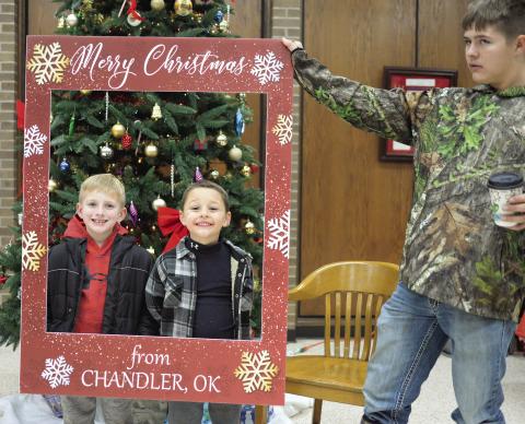 Many of the communities in Lincoln County had their Christmas parades and celebrations Saturday evening. Beckett Jackson and Blake McLain from Wellston, above, took advantage of the photo booth in the Lincoln County Courthouse during Chandler’s festival. Holding the frame for them is Justin Kelley. For photos from the Stroud parade, please see Page 5A. For photos from the Chandler parade, see Page 6A. Photo/Brian Blansett