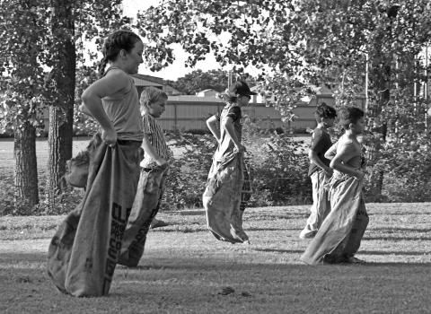 A group of children race down the field to the finish line during the sack races at Davenport’s Fourth of July celebrations. The town celebrated on Friday, July 3, at North Park. The evening included a number of games, hot dogs, free watermelon, a hot dog eating contest and ended with a firework display. Photo/Emily Kalka