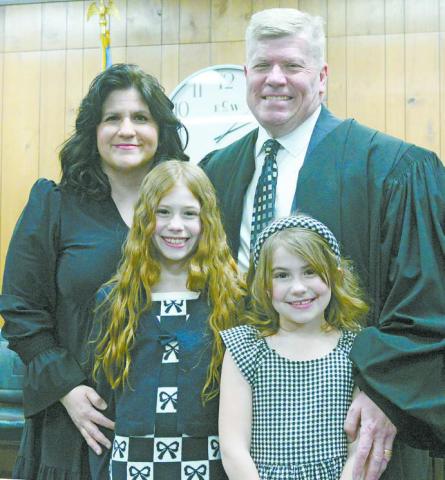Joseph A. Dobry was sworn in as associate district judge Monday afternoon. After putting on his robe, he posed in his courtroom with his wife, Laura Dobry, and daughters, Ella, left, and Cara. Photo/Brian Blansett