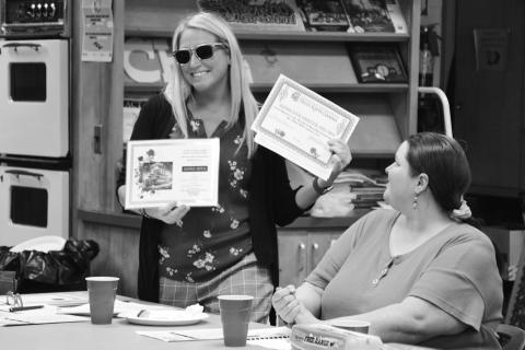 President Rachel Karger displays certificates Alpha Iota received at the OSO Convention in June. Member Jennifer Green looks on.