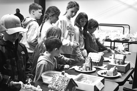 A group of 4-H members from across Lincoln County carefully select their favorite gingerbread house. The group gathered at the new OSU Extension Office building on the Lincoln County fairgrounds to put together thank you gifts for businesses that sponsor 4-H on Dec. 22. They also held a gingerbread house contest. There were kids from just about every 4-H club in the county at the event. Photo/Emily Kalka