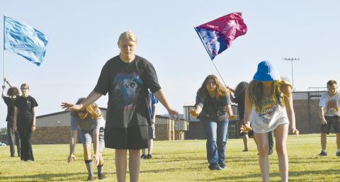 Damon Brown (center), along with Suzeanna Asher, Brooklynn Davis and Ayden Isaak to the right and Alexander St. Clair and Keelie Vaughn to the left, work through the formation for their marching band program for this year on July 24 at McLoud High School. Photo/Emily Kalka