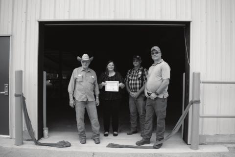 Pictured to the right, from left to right: Troy Evans, Alicia Wagnon, Carl Munson and Lee Doolen stand in the doorway of the newly completed east wall. Photo/Chelsea Weeks.