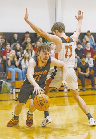 Agra’s Tevin Hutchinson dribbles around Carney’s Lukas Watts along the baseline last week. Both teams start the playoffs this week, with Agra playing Thursday and Carney Friday. Photo/Rick Hester