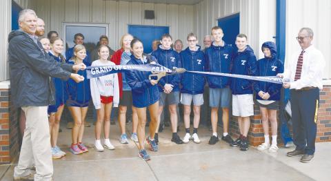 Runner Lexi Martzall cuts the ribbon held up by Superintendent Scott Baade (left) and High School Principal Freddie Hall (right) on the new track facility at Chandler Public Schools. The building contains locker rooms, a coaches’ office and a concession stand. It’s located next to the track and behind the softball field at the high school complex. Photo/ Emily Kalka