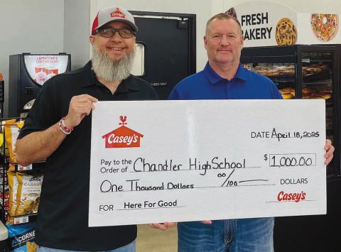 Casey’s District Manager Jared Morrison presents a check for $1,000 to Chandler High School Principal Geoff Metheny. Photo/provided