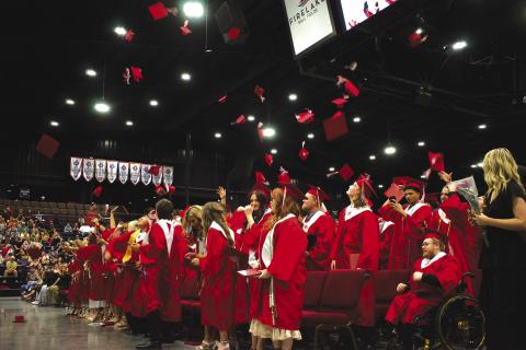 The graduating class of 2026 from McLoud High School tosses their hats into the air at the end of the ceremony in Firelake Arena on May 23. Photo/Emily Kalka