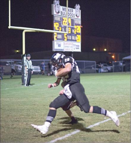 Caden Wolford carries a would-be Kellyville tackler across the goal line on the last of his five touchdown runs Friday night. Photo/Brian Blansett