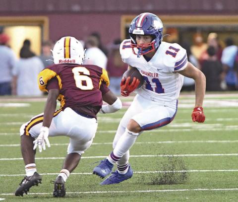 Chandler’s Ty Garver (11) kicks up a pile of turf pellets as he cuts inside of Clinton’s Marquis Martin (6) Friday night. Photo/Brian Blansett