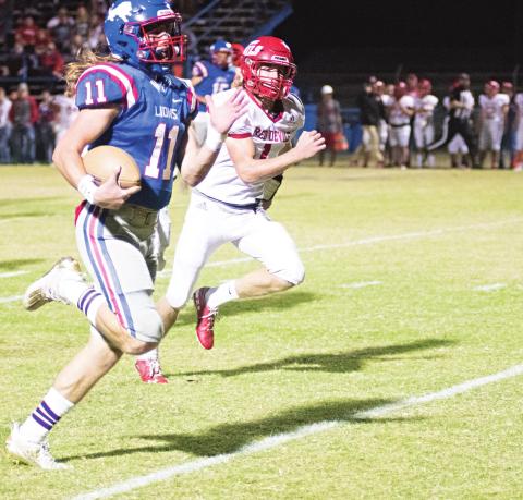 Chandler quarterback Kaden Jones (11) and Prague’s Trip Davis race to the end zone in the first half of the Lions’ 60-12 win Friday night. Photo/Brian Blansett