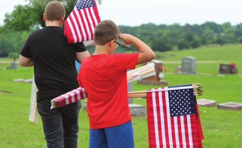 Mason Eversole pauses to salute a veteran’s grave while placing flags at Stroud Cemetery last year in anticipation of the Veterans Day holiday. He is the son of Jerrod and Kristen Eversole. Photo/Lily Huff