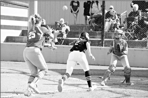 Meeker runner Callie Sellers (2) takes evasive action as Prague third baseman Demi Manning and catcher Kinsey Rice work a rundown. Sellers was safe, but Prague won the game, 5-4. Photo/Brian Blansett