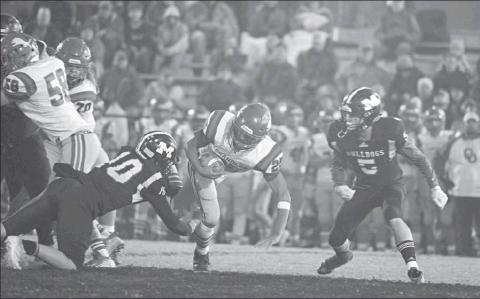 Above, Meeker’s Jarrett Marks (10) and Dakota Gabbert (5) bring down Chandler runner Casmen Hill (5). Photo/Brian Blansett