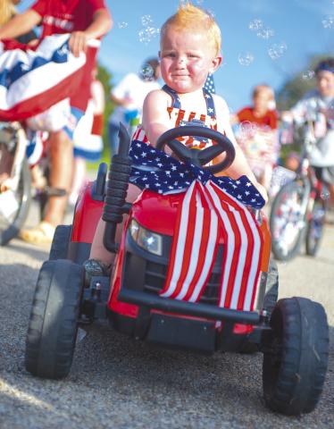 Colter Plunket from Meeker had a stylish ride in the first annual patriotic parade at the Meeker’s Independence Day celebration at Meeker Lake Friday. Not only was it tricked out in red, white and blue, it had a bubble machine in the back. Photo/Brian Blansett