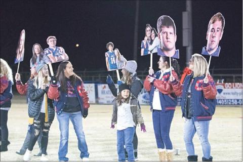 Chandler’s seniors, hoisted aloft and celebrated on fathead cutouts, and the Lions closed out their season with an emphatic W, walloping Holdenville 71-18, Friday night and nailing down third place in District 2A-2. Below, senior Caedon Parris sets off on a long run. Photos/Braden Wade