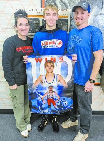 Chandler’s Landon Earp, at left with his parents, Jaclyn and Shane Earp, recorded his 100th career wrestling victory last week in less than three full seasons of high school competition. A junior, he qualified for the state tournament as a freshman and sophomore. For more, see Page 1C. Photo/Jennifer Pryor. Senior Zalen Smith, pictured above with his teammates, scored the 1,000th point of his career in the Lions’ win over Tecumseh Friday. He was at 999 points and put in a bucket from the lane in the first q