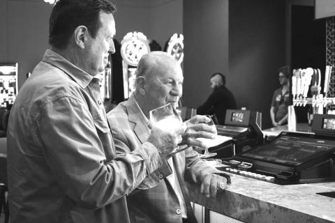 Legendary Oklahoma coaches Bob Stoops (left) and Barry Switzer (right) enjoy the signature cocktail made from Stoops’ tequila brand Rock N Roll Tequila at the sports bar in Harrah’s Oklahoma. The two also did a ceremonial first play while taking part in the casino’s grand opening on April 9 in Chandler. Photo/Emily Kalka