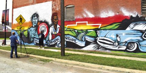 Artist Nick Blanchard is interviewed for a video introducing new murals in Stroud as the town partook in the Route 66 Mural Festival on July 17. Photo/Emily Kalka