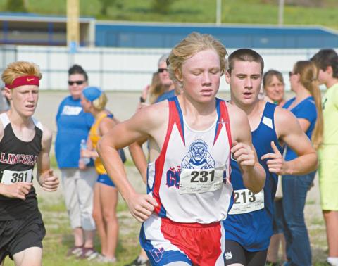 Above left, Elihu Davis of Chandler (231) at roughly the halfway mark of the Stroud cross country meet. Above right, Riley Randall of Meeker and Coltin Fitch from Lincoln Christian are shoulder-to-shoulder. Photos/Brian Blansett
