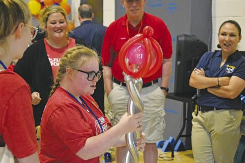 Chandler Senior Jaden Sumpter receives a balloon wand at one of the stations during the Special Olympics last Thursday. Heavy rain the night and morning before led to the cancellation of outdoor sports at the annual event, but many participants were invited to take part in Athletes of the Future at the Colvin Annex at Oklahoma State University in Stillwater. Photo/Emily Kalka