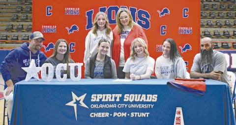 Jordan Glasgow (center right, seated) signs a letter of intent to cheer at Oklahoma City University on Dec. 19 at Freeman Fieldhouse, surrounded by her family and coaches. The Chandler senior has been on the cheerleading team since eighth grade, according to CHS coach Cynthia Snider. Pictured from left to right, front row: Chad Glasgow, Rachel Glasgow, OCU Coach Erin Johnson, Jordan, April McDaniel and Nathan McDaniel. From left to right, back row: sister Jade Glasgow and Snider. Photo/Emily Kalka