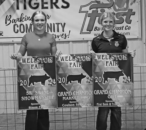 Hogs: Rowan Shelton (left) and Paige Keeling (right) pose with Keeling’s banners. Keeling won Sr. Swine Showman, Grand Champion Market Hog, Grand Champion Gilt and Reserve Grand Gilt at the Wellston Fair Livestock Show. Photo/Caylyn Cunningham