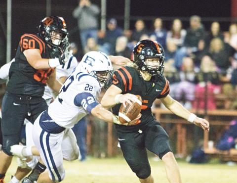 Davenport quarterback Carson Funk slips away from Regent Prep’s Duvon Boshoff (22) Friday night. Photo/Chelsea Weeks