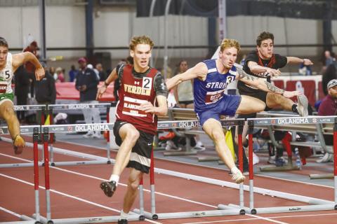 Stroud’s Jacob Beck (in blue) clears a hurdle en route to a state runnerup finish at the Indoor State Championships Saturday at the Mosier Indoor Athletic Facility at OU. The event was sponsored by the Oklahoma Cross County &amp; Track Coaches Association. Photo/Mario Holland