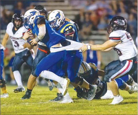 Meeker’s Mason Fullbright wins the tug-of-war with a Bethel ballcarrier during the Bulldogs’ district victory Friday night. Photo/Rick Hester